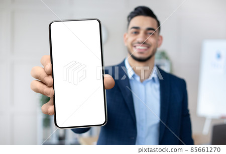 Handsome Arab Businessman Showing Smartphone With Blank White Screen At Camera Handsome Arab Businessman Showing Smartphone With Blank White Screen At Camera 85661270