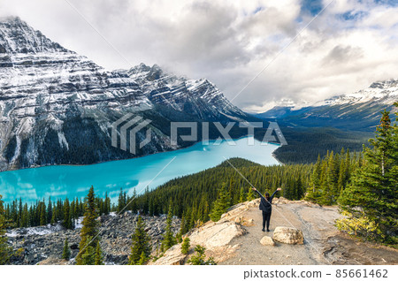 Peyto lake resemble of fox with woman traveler raised arm in Banff national park at Canada Peyto lake resemble of fox with woman traveler raised arm in Banff national park at Canada 85661462