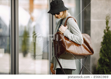 Portrait of a fashionable model with big brown bag outdoors 85661969