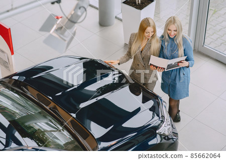 Stylish and elegant women in a car salon Stylish and elegant women in a car salon 85662064