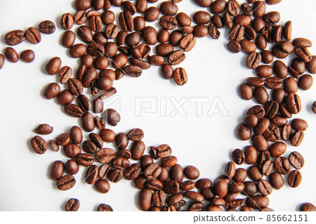 Heart shape roasted coffee beans with coffee beans background isolated on white Heart shape roasted coffee beans with coffee beans background isolated on white 85662151
