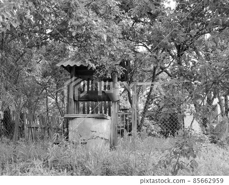Old well with iron bucket on long forged chain for clean drinking water Old well with iron bucket on long forged chain for clean drinking water 85662959