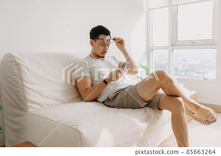 Middle age man with long eye sight try to look at the smartphone. 85663264