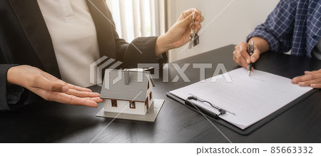 Real estate agent holding a key and asking costumer for contract to buy, get insurance or loan real estate or property. Real estate agent holding a key and asking costumer for contract to buy, get insurance or loan real estate or property. 85663332