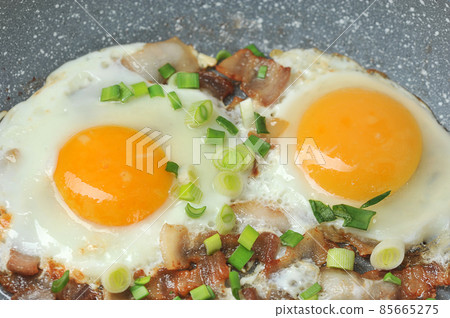 fried eggs with bacon and green onions in a frying pan fried eggs with bacon and green onions in a frying pan 85665275