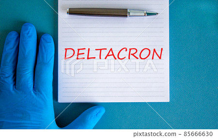New covid-19 deltacron variant strain symbol. Hand in blue glove with white note. The concept word Deltacron. Metalic pen. Medical and COVID-19 deltacron variant strain concept. Copy space. 85666630