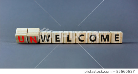 Welcome or unwelcome symbol. Turned wooden cubes and changed the word unwelcome to welcome. Beautiful grey table, grey background. Welcome or unwelcome and business concept. Copy space. Welcome or unwelcome symbol. Turned wooden cubes and changed the word unwelcome to welcome. Beautiful grey table, grey background. Welcome or unwelcome and business concept. Copy space. 85666657