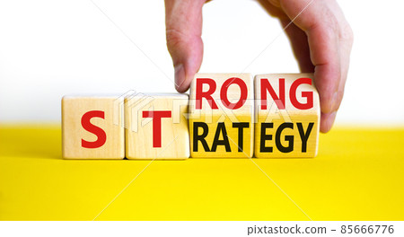Strong strategy symbol. Businessman turns wooden cubes with words 'strong strategy'. Beautiful yellow table, white background, copy space. Business and strong strategy concept. 85666776