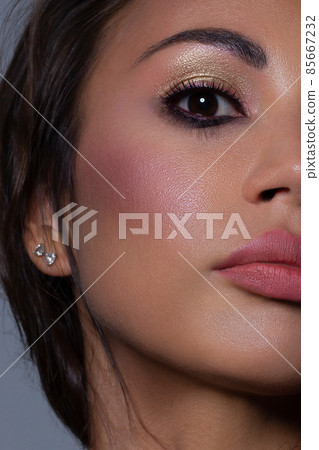 Half the face of a young sexy woman with pink lipstick on her lips and black eyeliner. Classic makeup and straight long hair. Evening make-up, cosmetology, spa, cosmetics, rejuvenation Half the face of a young sexy woman with pink lipstick on her lips and black eyeliner. Classic makeup and straight long hair. Evening make-up, cosmetology, spa, cosmetics, rejuvenation 85667232