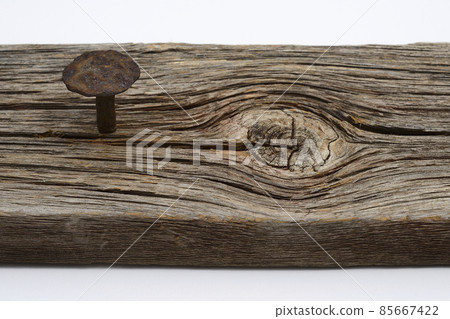 rusty forged nail hammered into an old board 85667422