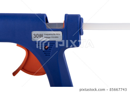 Glue stick inside an electric glue gun on a white background. Glue stick inside an electric glue gun on a white background. 85667743