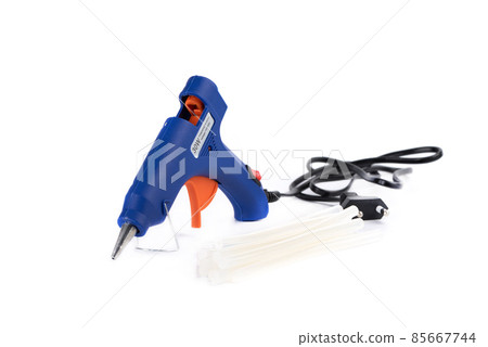 Electric hot glue gun and gun rods on a white background. Electric hot glue gun and gun rods on a white background. 85667744