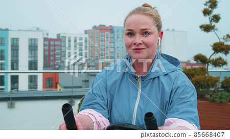 Woman performs aerobic endurance training workout cardio routine on the simulators, cycle training 85668407