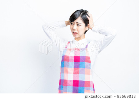 Housewife in an apron holding her head Housewife in an apron holding her head 85669818