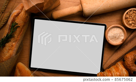 Digital tablet touchpad white screen mockup with bread background. Digital tablet touchpad white screen mockup with bread background. 85675062