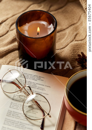 book, glasses, coffee and candle on warm blanket 85675404