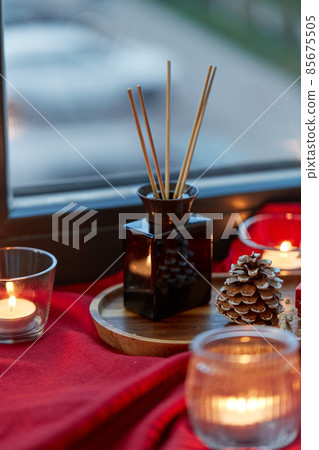 aroma reed diffuser and candles on window sill 85675505