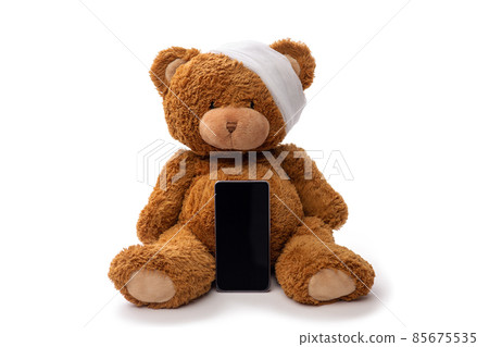 teddy bear toy with bandaged head and smartphone 85675535