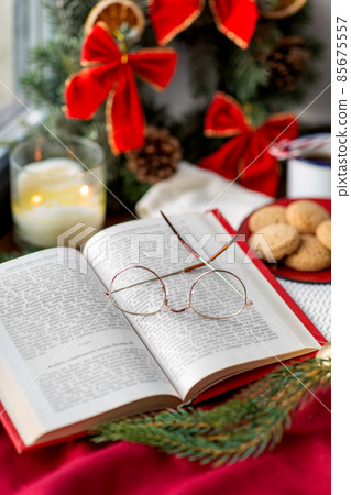 close up of open book and glasses on christmas 85675557