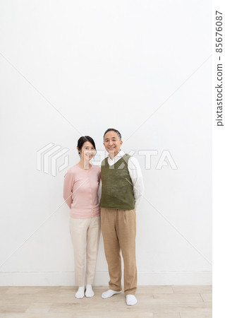 Senior couple standing in front of a white wall 85676087