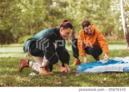 happy couple setting up tent outdoors happy couple setting up tent outdoors 85676145