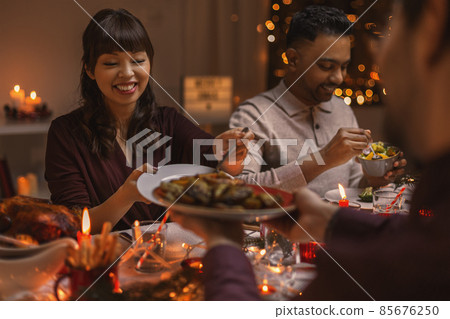 happy friends having christmas dinner at home happy friends having christmas dinner at home 85676250
