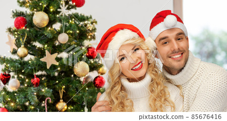 happy couple in santa's hats on christmas happy couple in santa's hats on christmas 85676416