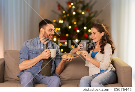 couple drinking tea with cookies on christmas 85676445