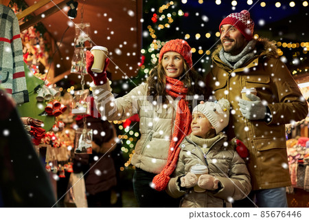 family with takeaway drinks at christmas market 85676446