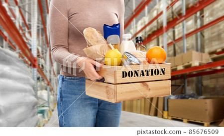 woman holds box with food donation at warehouse woman holds box with food donation at warehouse 85676509