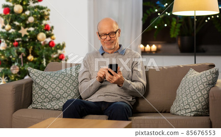 happy senior man with smartphone on christmas 85676553