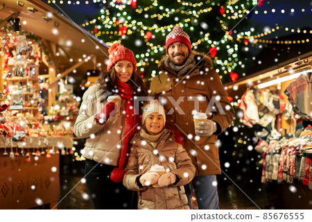 family with takeaway drinks at christmas market 85676555