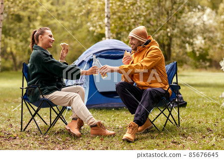 couple drinking beer with sandwiches at tent camp 85676645