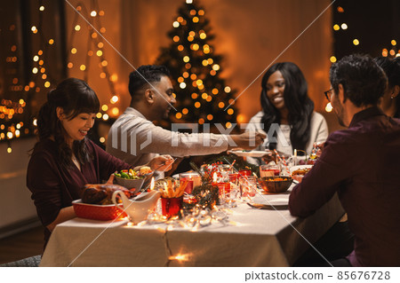 happy friends having christmas dinner at home happy friends having christmas dinner at home 85676728