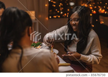 happy friends having christmas dinner at home happy friends having christmas dinner at home 85676730