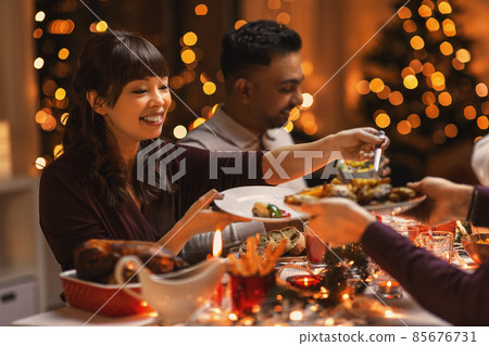 happy friends having christmas dinner at home happy friends having christmas dinner at home 85676731