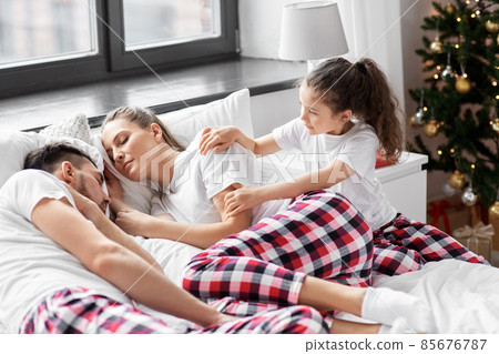 happy girl wakes her parents in christmas morning 85676787
