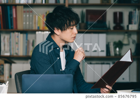 A man writing with a pen A man writing with a pen 85676795