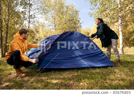 happy couple setting up tent outdoors happy couple setting up tent outdoors 85676803