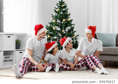 happy family sitting under christmas tree at home happy family sitting under christmas tree at home 85676817