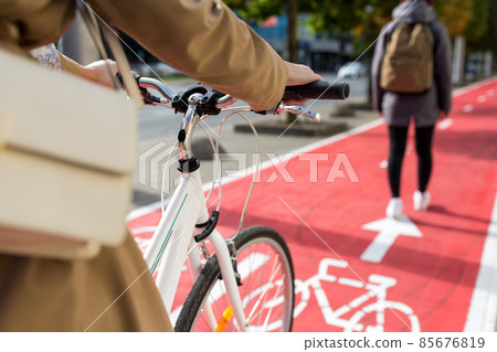 close up of cyclist behind pedestrian on bike lane 85676819