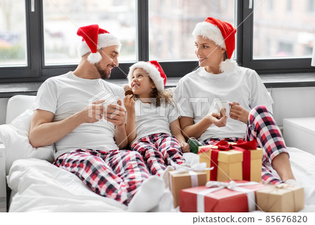 happy family eating coookies in bed on christmas happy family eating coookies in bed on christmas 85676820