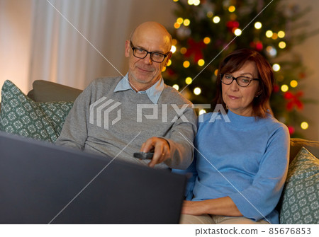 senior couple watching tv at home on christmas senior couple watching tv at home on christmas 85676853