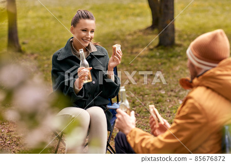 couple drinking beer with sandwiches at tent camp 85676872