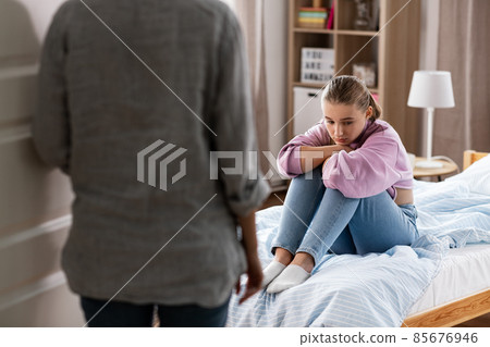 mother and sad daughter sitting on bed at home mother and sad daughter sitting on bed at home 85676946