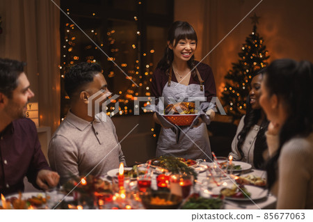 happy friends having christmas dinner at home happy friends having christmas dinner at home 85677063