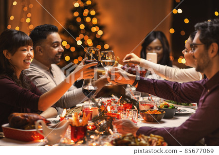 happy friends drinking wine at christmas party happy friends drinking wine at christmas party 85677069