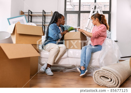 women unpacking boxes and moving to new home women unpacking boxes and moving to new home 85677125