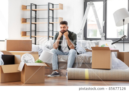 sad man with boxes moving to new home sad man with boxes moving to new home 85677126