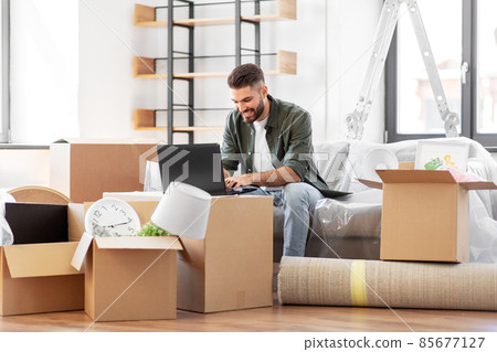 man with laptop computer and moving into new home man with laptop computer and moving into new home 85677127